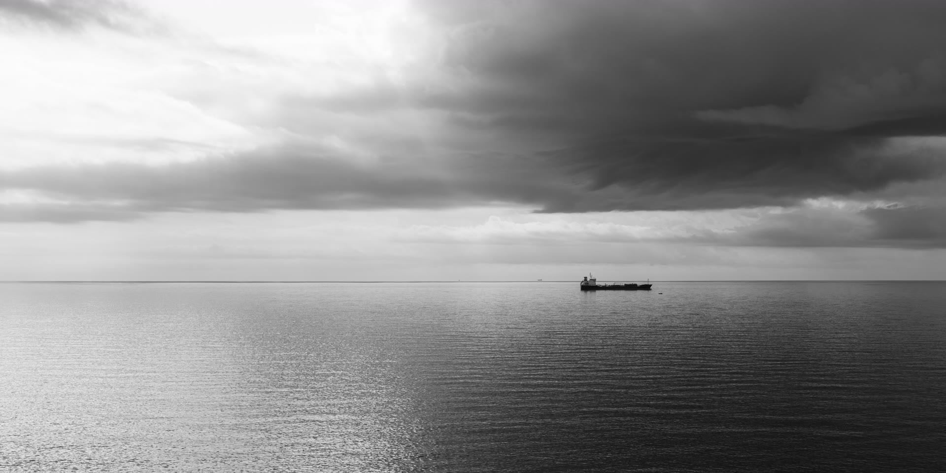 Open sea under storm cloud, with AIUS Marine detection markers on a cargo vessel and nearby craft